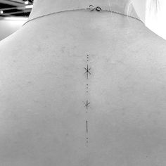 the back of a woman's neck with an arrow tattoo on it