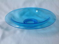 a blue glass bowl sitting on top of a white table