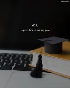 a graduation cap sitting on top of a book next to a computer keyboard with the words help me to achieve my goals written in arabic