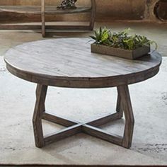 a wooden table sitting on top of a white floor next to a potted plant