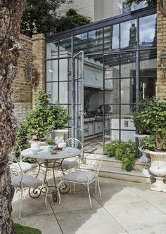 an outdoor dining area with potted plants on the patio