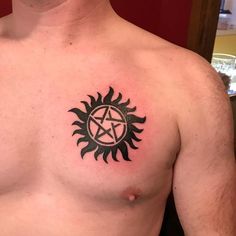 a man with a tattoo on his chest has a pentagramil in the middle