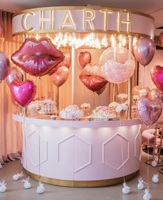 a table with pink and gold balloons on it in front of a wall that says charlotte