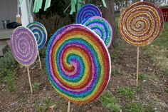 colorful lollipops on sticks in front of a house with grass and trees