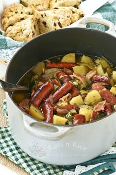 a pot filled with sausage and potatoes on top of a table next to other foods