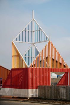 the building is made out of red, white and blue corrugated sheets that are stacked on top of each other