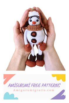 a hand holding a small crocheted snowman doll in it's hands