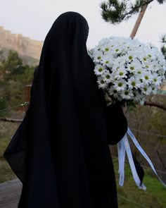 a nun holding a bouquet of white flowers