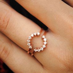 a woman's hand with a ring on it that has diamonds in the middle