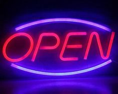 an open sign lit up in the dark with red and blue lights on it's sides