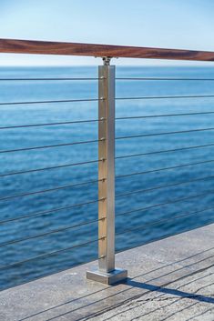 a skateboard is sitting on the edge of a railing near the water's edge