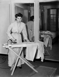 an old photo of a woman ironing clothes