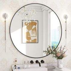 a bathroom with a large round mirror on the wall above it and a white sink