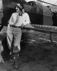 a man standing next to an airplane on top of a field