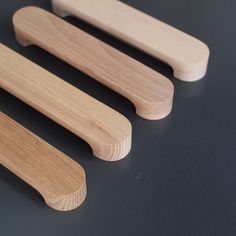 three wooden handles sitting on top of a black table next to each other and one is empty