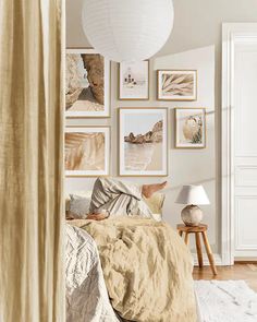 a bedroom with white walls and pictures on the wall