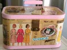 a pink suitcase with pictures of women in dresses on the front and side, sitting on top of a counter