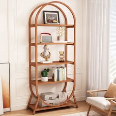 a living room with a book shelf and chair next to the window in front of it