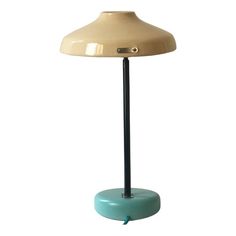 a lamp that is on top of a blue base with a black metal pole and light bulb