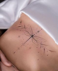 a woman's back with a tattoo on her stomach and stars in the background