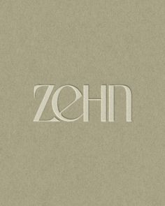 the word zehn written in white paper on a beige background with an oval logo