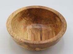 a wooden bowl sitting on top of a white table