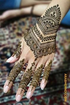 a woman's hand with henna tattoos on it, and the bottom half of her hands