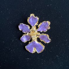 "Orchid flower brooch or pendant. Vintage early 1980s Hand painted lavender purple enamel, trimmed in 24K gold. Wt. 0.4oz Size: 1-3/4\" x 1-1/4\" Pin back closure and loop for chain. RISIS.  Each pin is unique, made from a real orchid blossom that's been hand painted and gold plated Also known as the Singapore orchid, it is a hybrid orchid that was chosen as the national flower in 1981. Stamped. Papilionanthe Miss Joaquim, is the flower most associated with hybrids, and it represents Singapore's Gold Enamel Costume Jewelry Brooches, Collectible Gold Flower Enamel Pin, Lavender Brooch Jewelry As A Gift, Gold Flower Enamel Pin Gift, Gold Flower Enamel Pin For Gift, Purple Orchids, Orchid Flower, Flower Brooch, Singapore