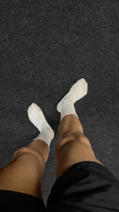 a person wearing white socks and black shorts