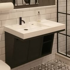 a white sink sitting under a bathroom mirror