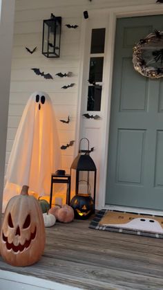 a front porch decorated for halloween with pumpkins and ghost decorations