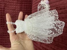 a hand is holding a piece of white lace