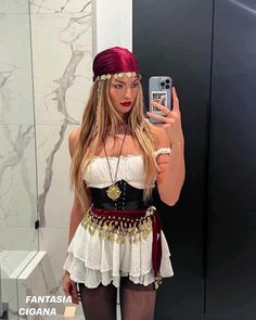 a woman taking a selfie in front of a mirror wearing a costume and headpiece