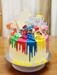 a birthday cake decorated with colorful icing on a table