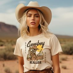 Embrace western charm with our Skeleton Cowboy Western Graphic Tee, an essential addition to your Cowboy Killer collection! Designed for comfort and durability, this oversized graphic tee seamlessly blends rugged aesthetics with modern flair. 🌵 Premium Quality: Crafted from 100% Combed and Ringspun Cotton, this tee guarantees unmatched comfort. (Note: Heather colors feature a polyester blend.) 🌵 Featherlight Feel: Weighing a mere 4.2 oz, this tee offers a lightweight fit suitable for daily wea Rodeo Graphic Crew Neck T-shirt, Rodeo Graphic Tee With Crew Neck, Relaxed Fit Crew Neck T-shirt For Rodeo, Western Style Relaxed Fit Crew Neck T-shirt, Trendy Crew Neck T-shirt For Ranch, Trendy Short Sleeve T-shirt, Cute Shirts For Women, Western Inspired Outfits, Cowboy Killer