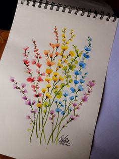 a drawing of colorful flowers on a white paper with watercolor pencils in it