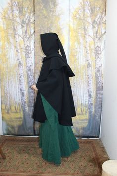 I make this beautiful, black, warm cape from a black wool fabric with a long hood. The material consists of 80% virgin wool and 20% polyester. The cape can be washed in the washing machine using the COLD wool wash program. Length at front: approx. 90 cm / 2`11" Length at the back: approx. 95 cm / 3`1" Hood circumference: approx. 80 cm / 2`7" Hood length: approx. 115 cm / 3`9" Colors may vary due to different renderings on mobile phones and computers. All prices stated are final prices plus deliv Gothic Hooded Winter Cape, Hooded Gothic Cape For Costume, Gothic Hooded Cape For Costume, Medieval Cape Outerwear For Costume Party, Elvish Hooded Costume Outerwear, Medieval Style Cape For Costume Party, Medieval Cape For Costume Party, Larp Cape For Halloween, Gothic Hooded Cape For Cosplay