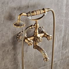 an antique brass faucet with hoses attached to it