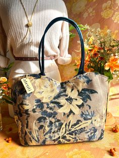 a purse sitting on top of a table next to flowers