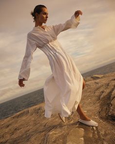 Embrace timeless elegance with our Pleated Caftan Dress. Crafted from crisp, lightweight 100% organic linen, it exudes sophistication. Featuring relaxed long sleeves, a stand collar, Japanese buttoning, and side splits to mid-thigh, it's a summer essential for the discerning individual. Linen Outfits, Long Summer Dress, Resort Wear Dresses, Summer Essential, 2024 Trends, Caftan Dress, Side Splits, Long Summer Dresses, Organic Linens