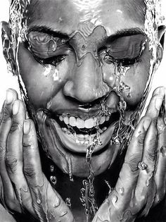 a black and white photo of a person with water on their face