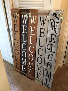 three wooden welcome signs sitting on top of a carpeted floor