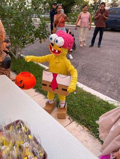 a person in a costume standing next to a table with candy and decorations on it