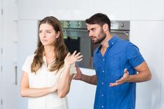 a man and woman standing in front of an oven with their hands folded out to each other