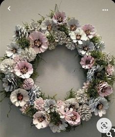 a wreath made out of pine cones and flowers