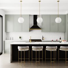 a kitchen with marble counter tops and gold bar stools