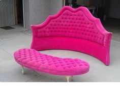 a pink couch sitting on top of a cement floor