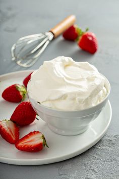 a white plate topped with whipped cream and strawberries