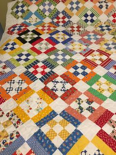 a multicolored quilt is laying on the floor