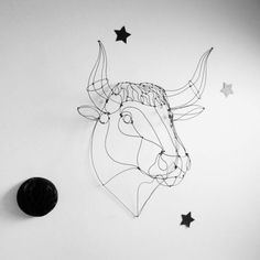 a wire sculpture of a bull's head with stars on the wall next to it